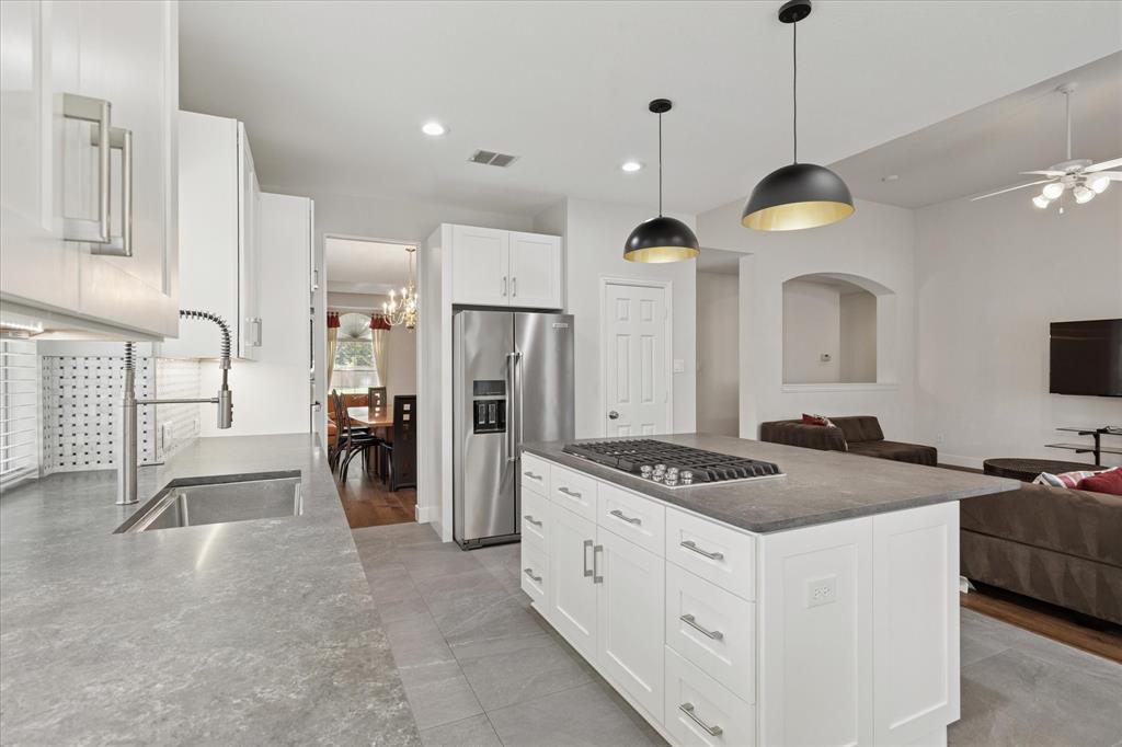 610 Spring Hill Drive Coppell, TX 75019 - Photo 6 of 15 a kitchen with stainless steel appliances kitchen island granite countertop a stove a refrigerator a oven a sink with a dining table and chairs