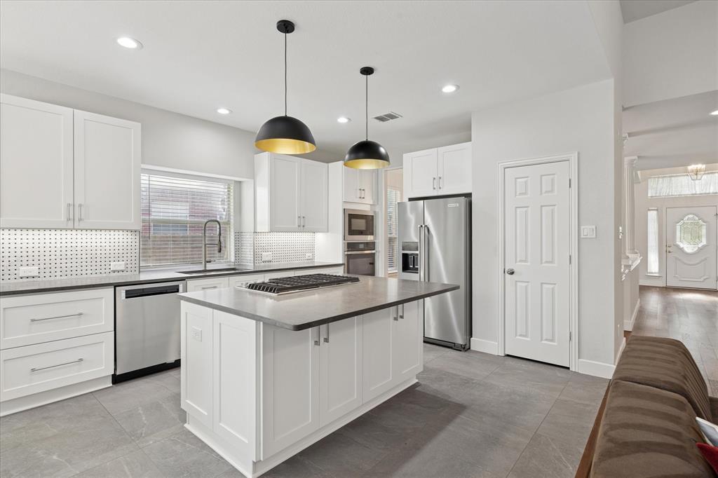 610 Spring Hill Drive Coppell, TX 75019 - Photo 7 of 15 a kitchen with stainless steel appliances granite countertop a stove and a refrigerator