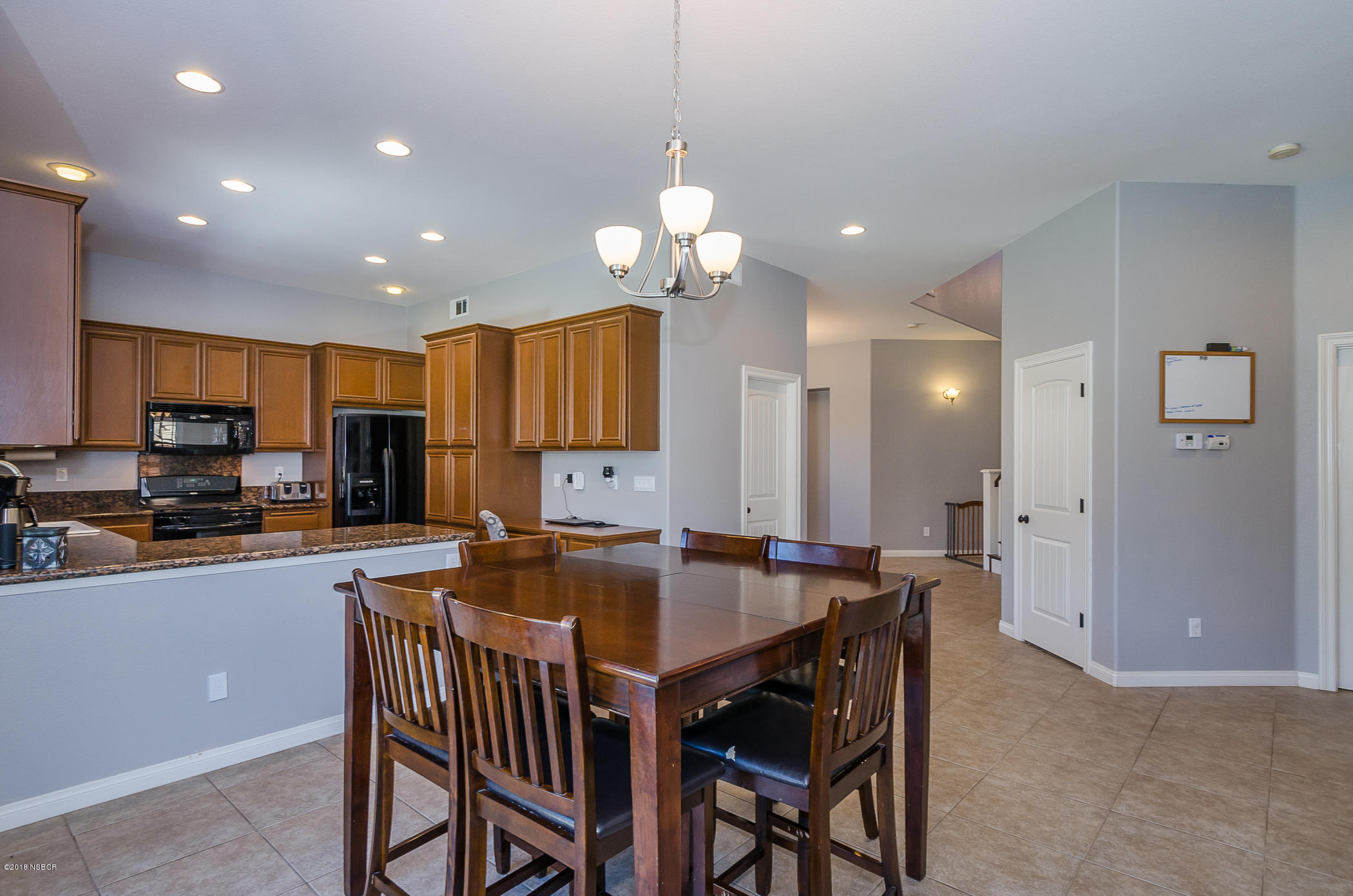 716 Enterprise Avenue Lompoc, CA 93436 - Photo 11 of 43 a kitchen with a dining table chairs stainless steel appliances and cabinets