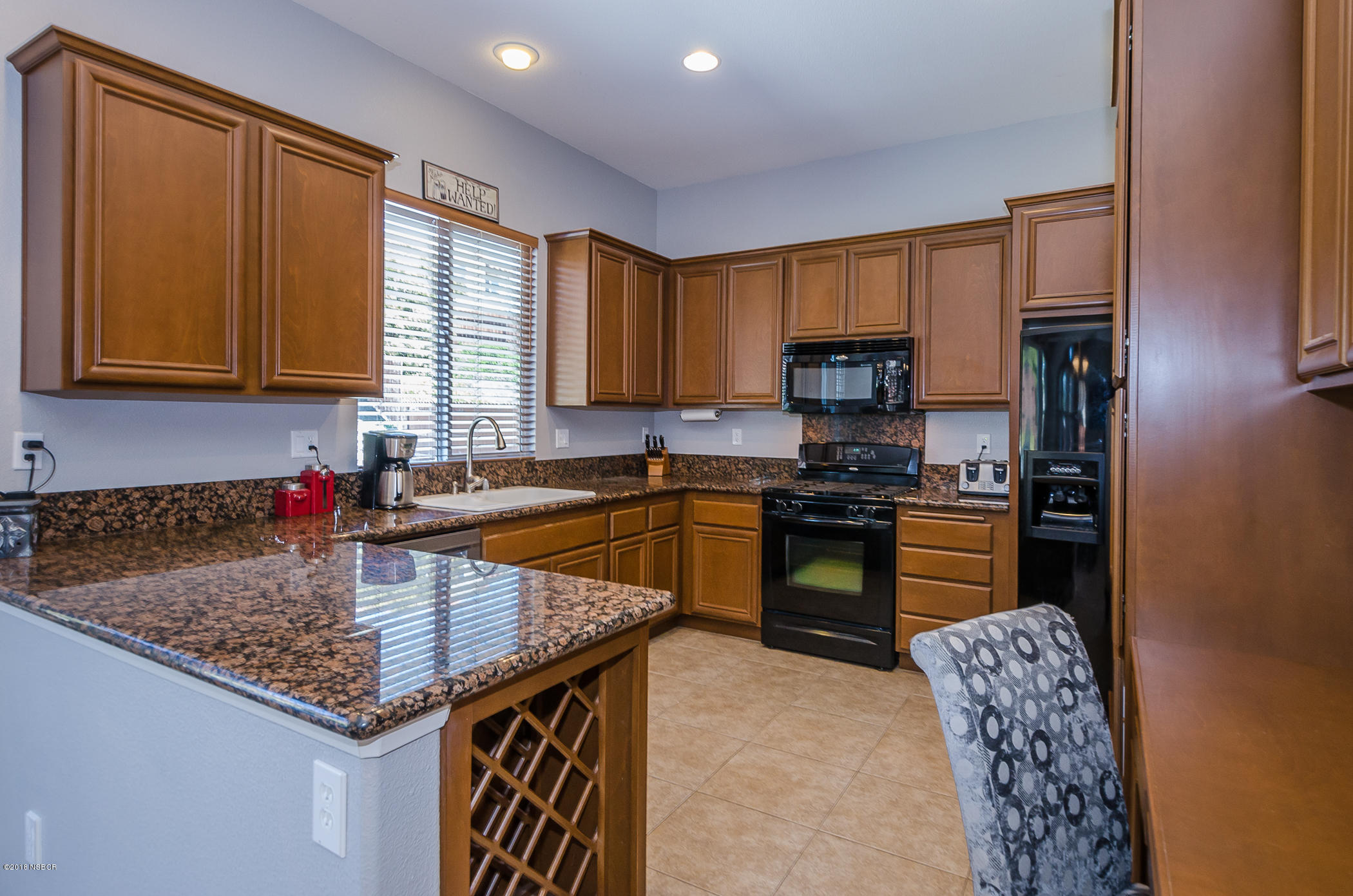 716 Enterprise Avenue Lompoc, CA 93436 - Photo 12 of 43 a kitchen with granite countertop a stove a sink dishwasher and a refrigerator