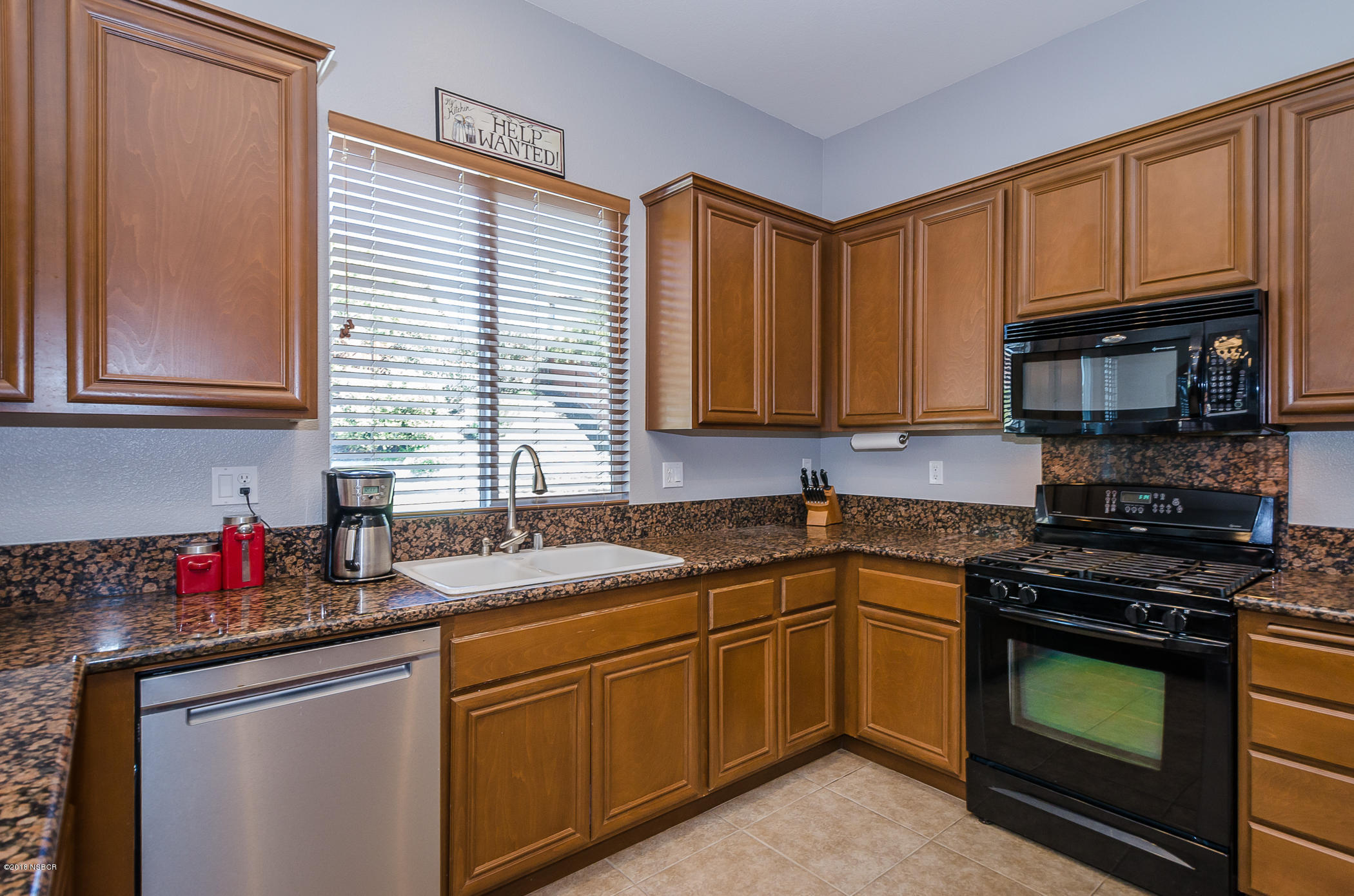 716 Enterprise Avenue Lompoc, CA 93436 - Photo 13 of 43 a kitchen with granite countertop a sink stove top oven and cabinets