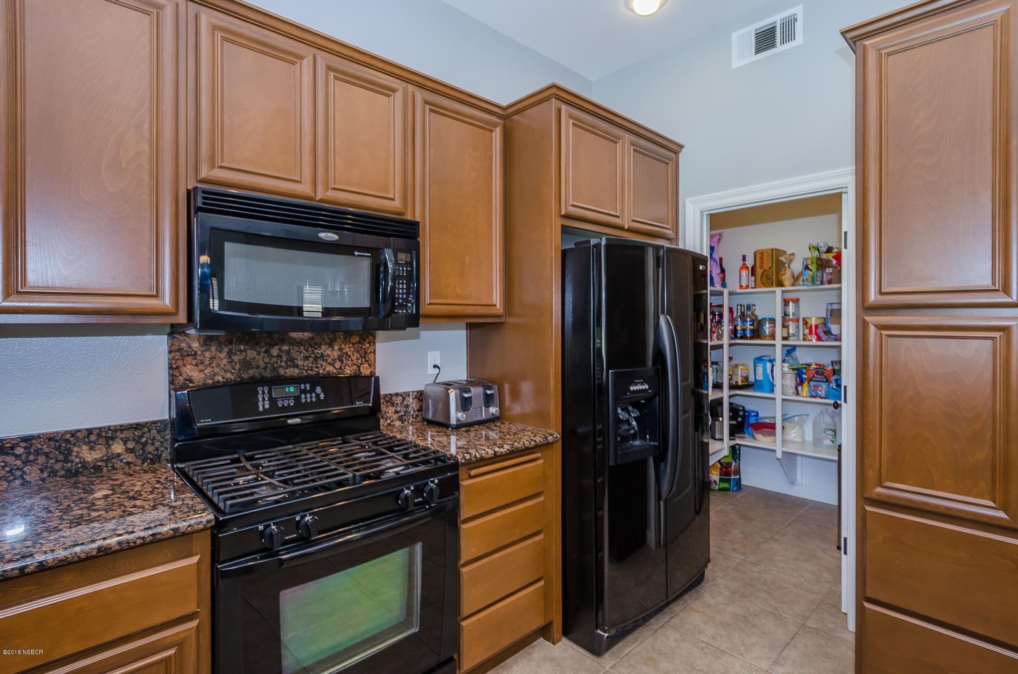 716 Enterprise Avenue Lompoc, CA 93436 - Photo 16 of 43 a kitchen with stainless steel appliances granite countertop a refrigerator stove and cabinets