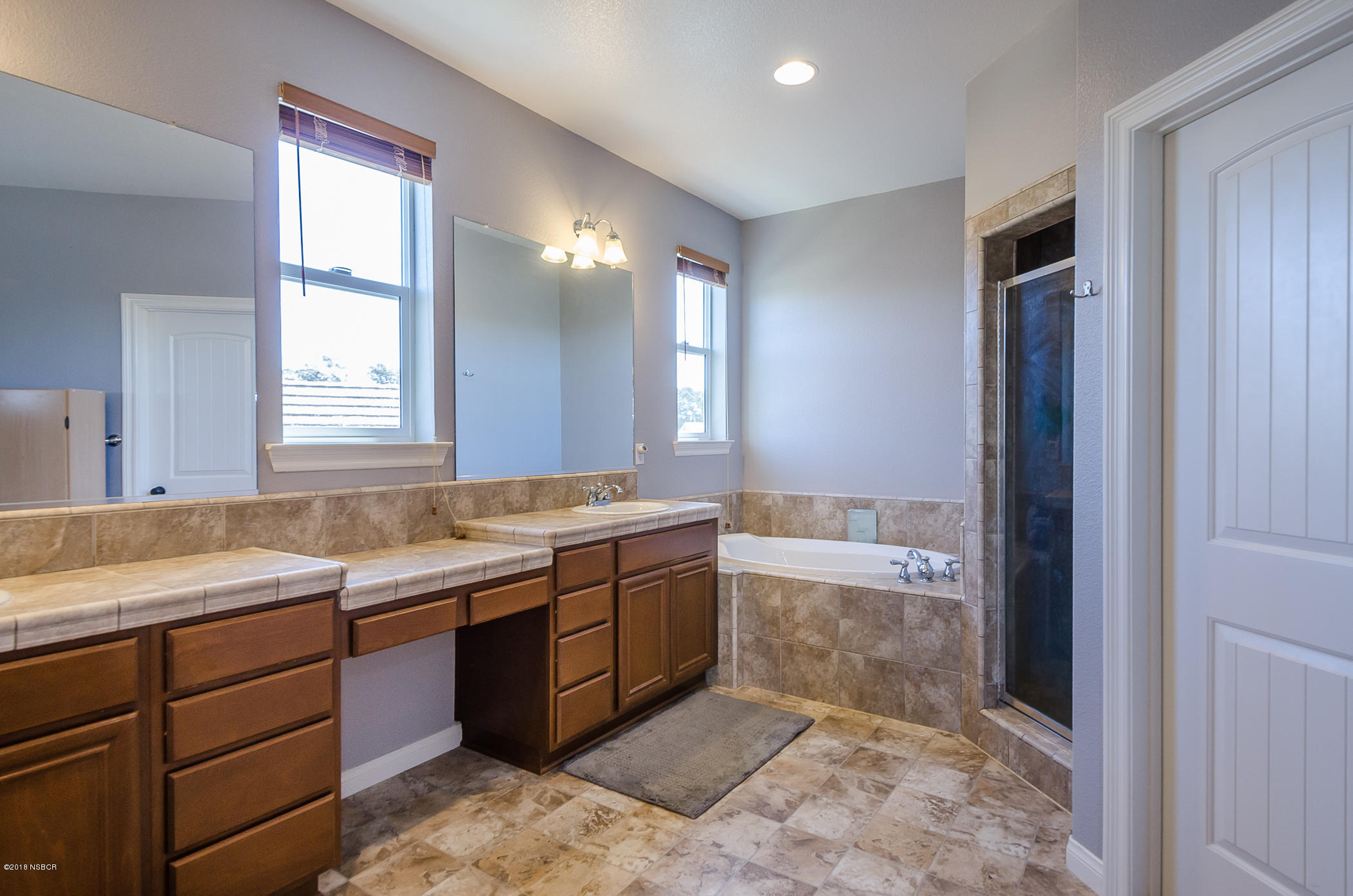 716 Enterprise Avenue Lompoc, CA 93436 - Photo 23 of 43 a spacious bathroom with a granite countertop sink a mirror and a bathtub