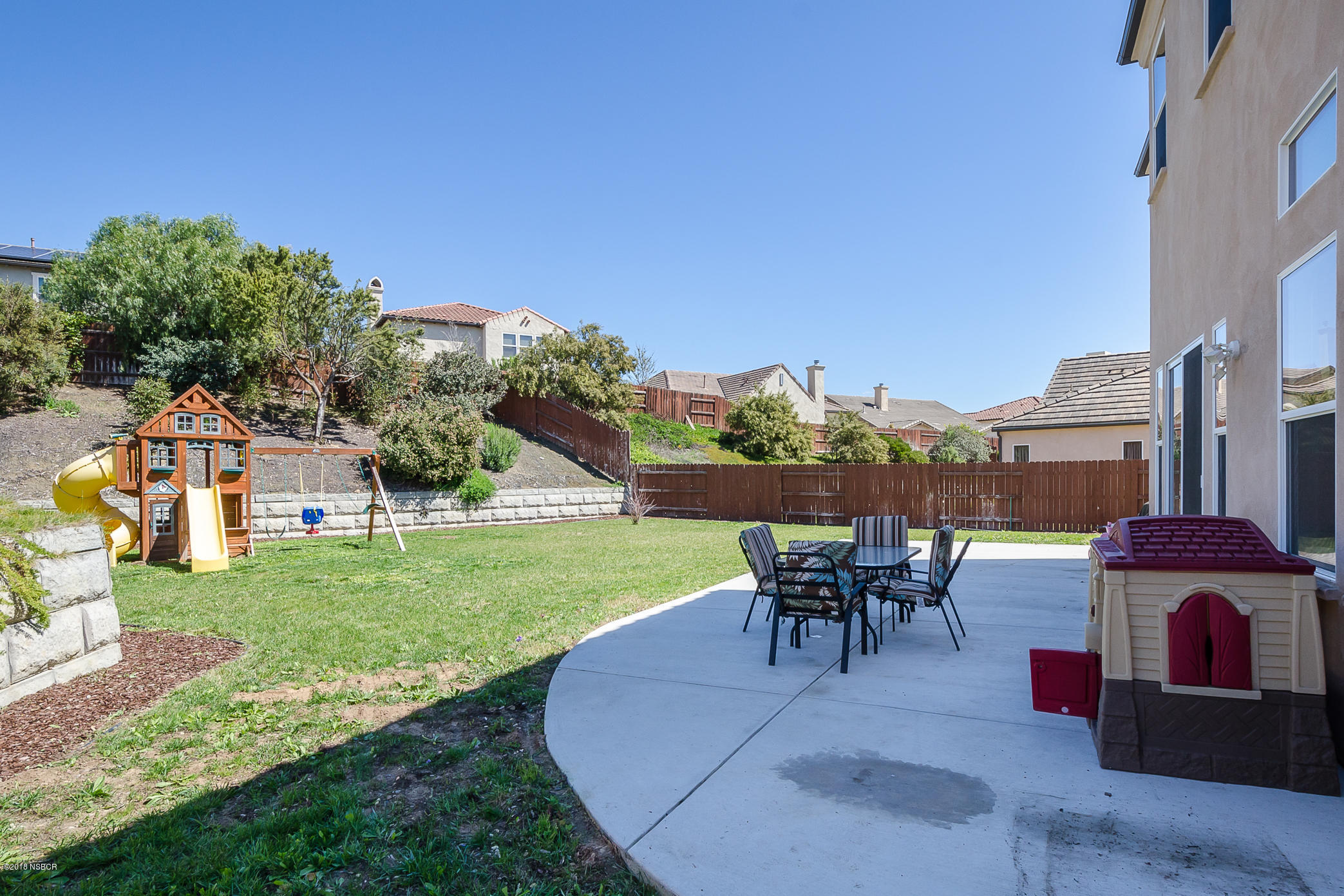 716 Enterprise Avenue Lompoc, CA 93436 - Photo 36 of 43 a view of a patio with table and chairs potted plants and a palm tree