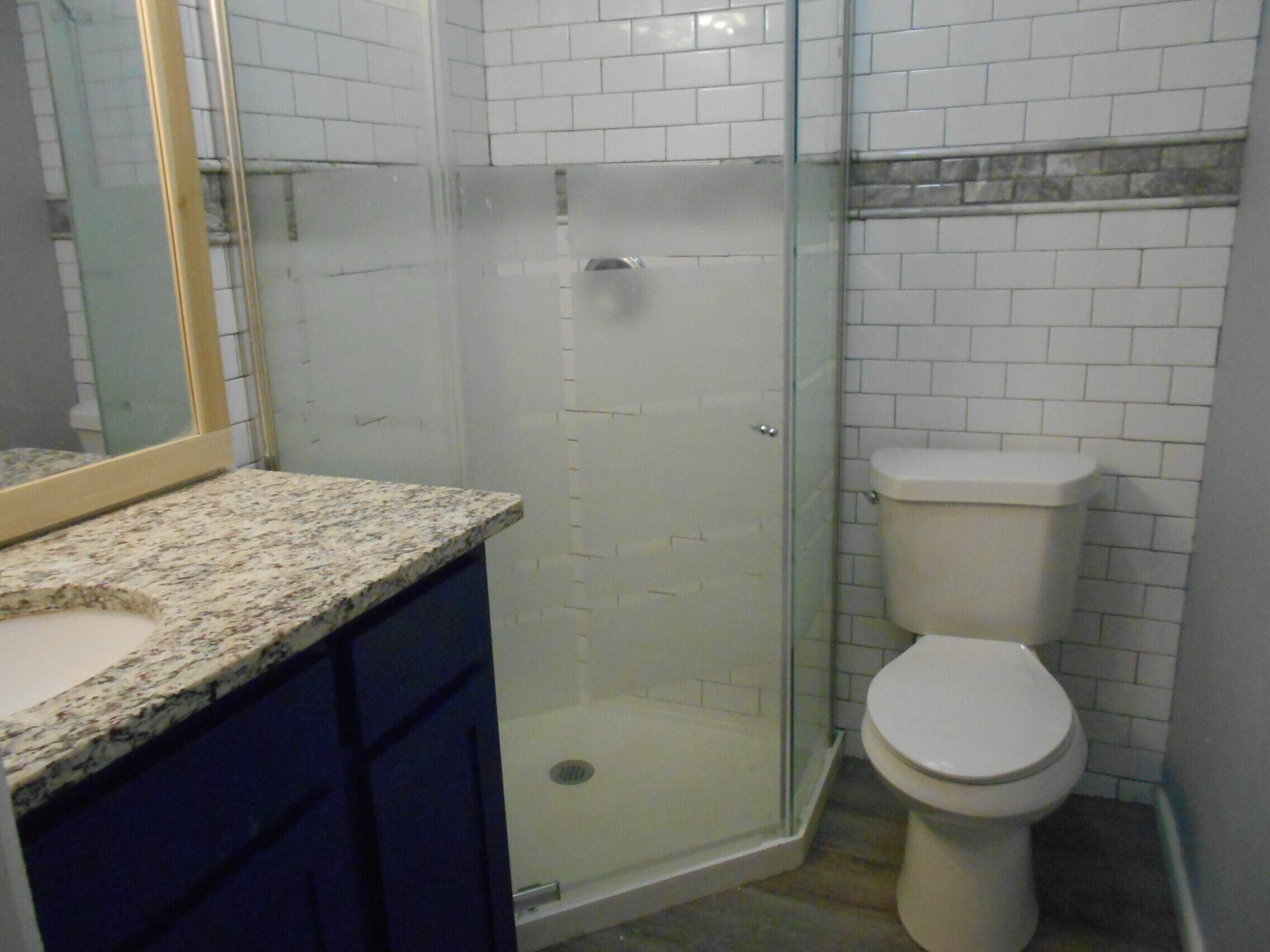 2614 31st Street Lubbock, TX 79410 - Photo 11 of 15 a bathroom with a granite countertop toilet and a sink