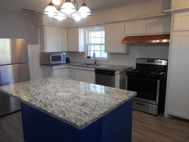 a kitchen with a center island refrigerator and cabinets