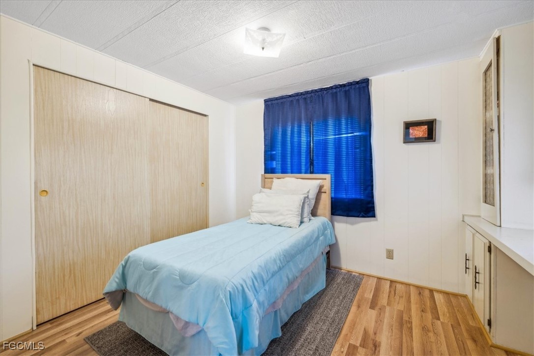 455 Cape Florida Way Naples, FL 34104 - Photo 27 of 35 a bedroom with a bed and wooden floor