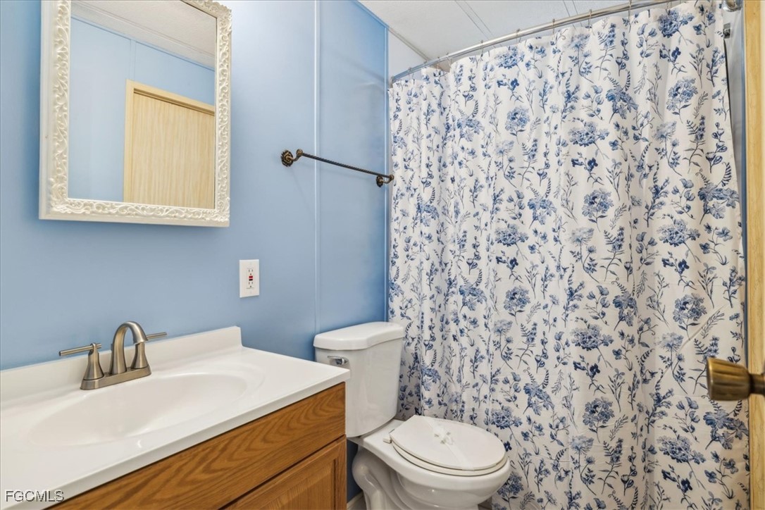 455 Cape Florida Way Naples, FL 34104 - Photo 29 of 35 a bathroom with a sink a toilet and a mirror