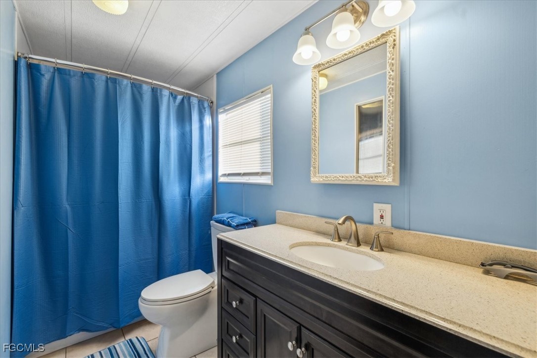 455 Cape Florida Way Naples, FL 34104 - Photo 31 of 35 a bathroom with a sink a toilet and a mirror