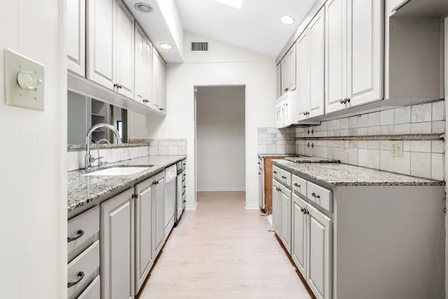 a kitchen with stainless steel appliances granite countertop a sink and a stove