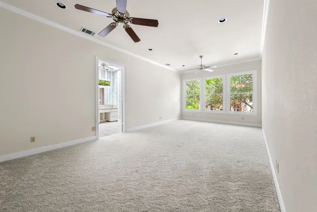 en empty room with windows and ceiling fan