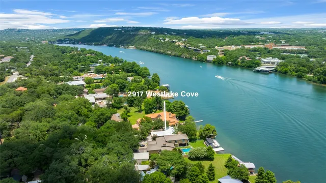 an aerial view of residential houses with outdoor space and lake view