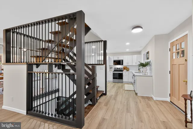 a view of a hallway with wooden floor and staircase
