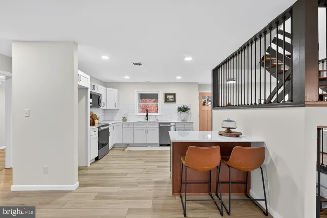a kitchen with granite countertop a sink stove and refrigerator