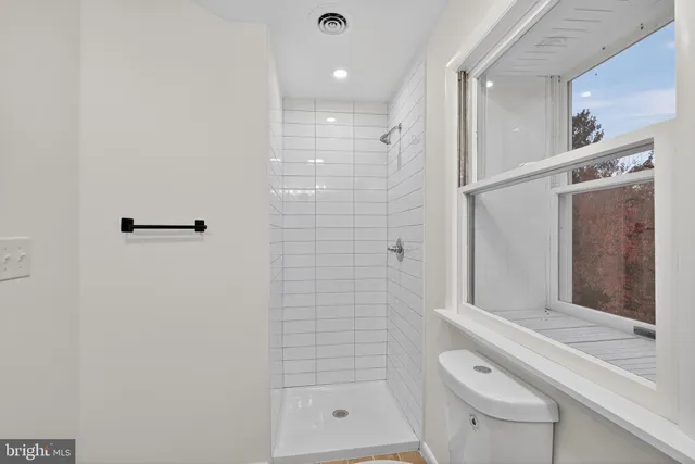 a view of an empty room with window and closet area