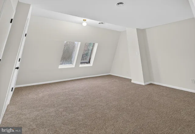 a view of an empty room with wooden floor and stairs