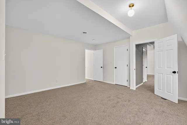 a view of an empty room with wooden floor and windows