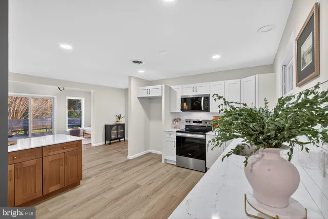 a large open kitchen with stainless steel appliances kitchen island granite countertop a stove refrigerator and a sink with granite countertops