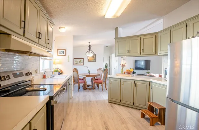 a kitchen with a sink a stove refrigerator and cabinets