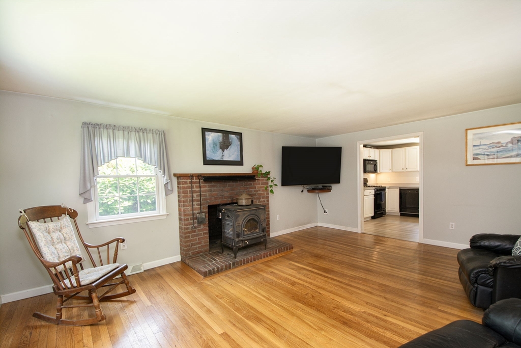 45 Cornet Stetson Road Scituate, MA 02066 - Photo 9 of 23 a living room with furniture a flat screen tv and a fireplace