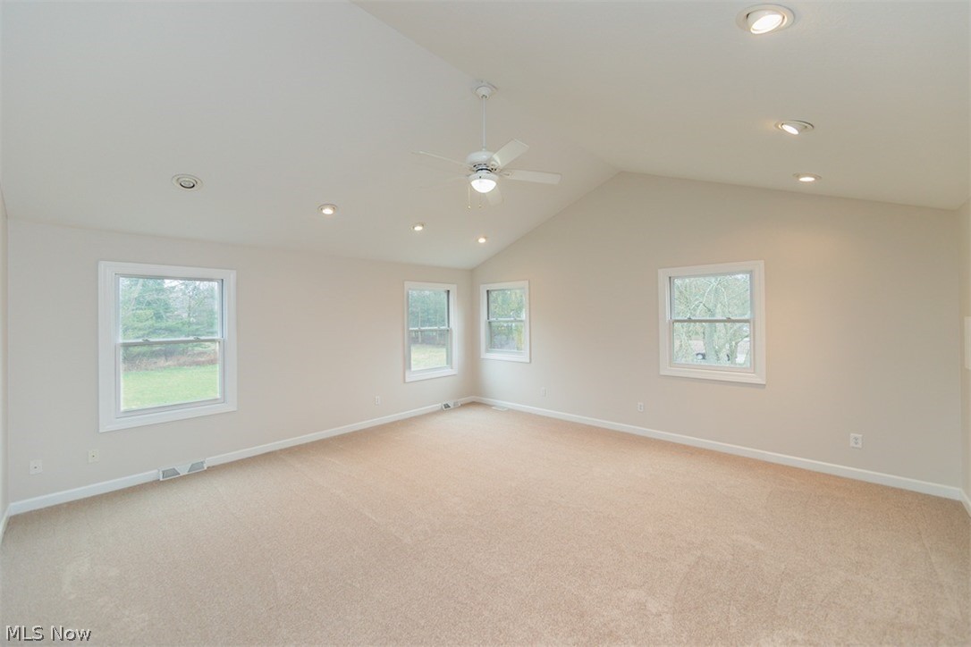 6947 Som Center Road Solon, OH 44139 - Photo 49 of 50 Carpeted spare room featuring vaulted ceiling, a healthy amount of sunlight, and ceiling fan