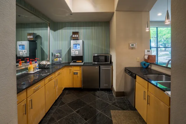 a kitchen with granite countertop a sink stove and cabinets