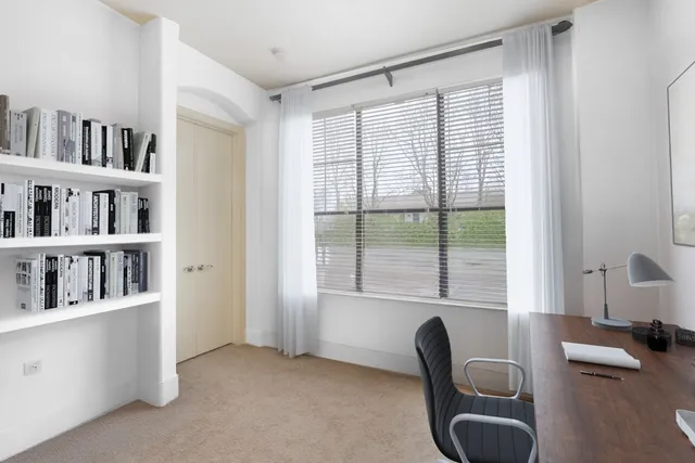a view of a workspace with furniture and a window