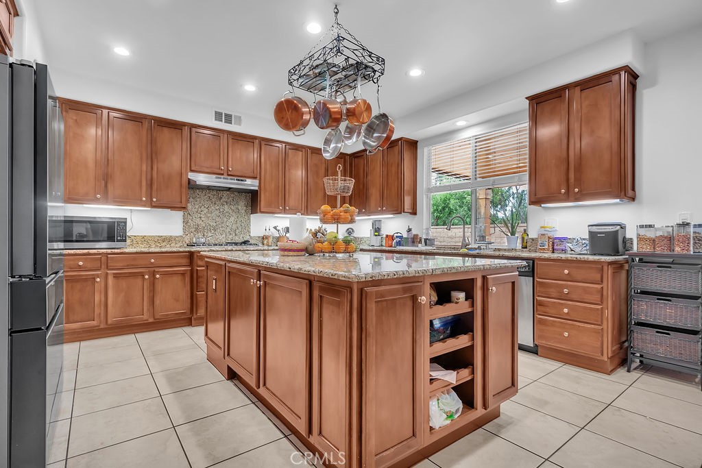 42740 Portraits Lane Temecula, CA 92592 - Photo 11 of 68 a kitchen with stainless steel appliances granite countertop a refrigerator and a stove top oven