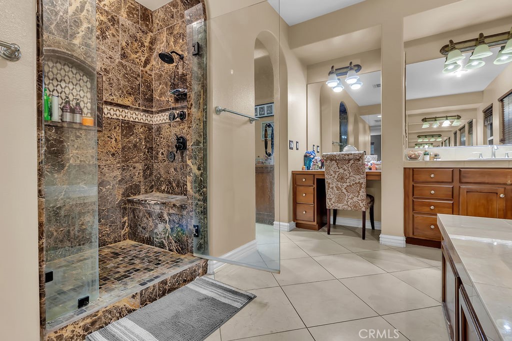 42740 Portraits Lane Temecula, CA 92592 - Photo 35 of 68 a large bathroom with a glass door shower a sink and a mirror