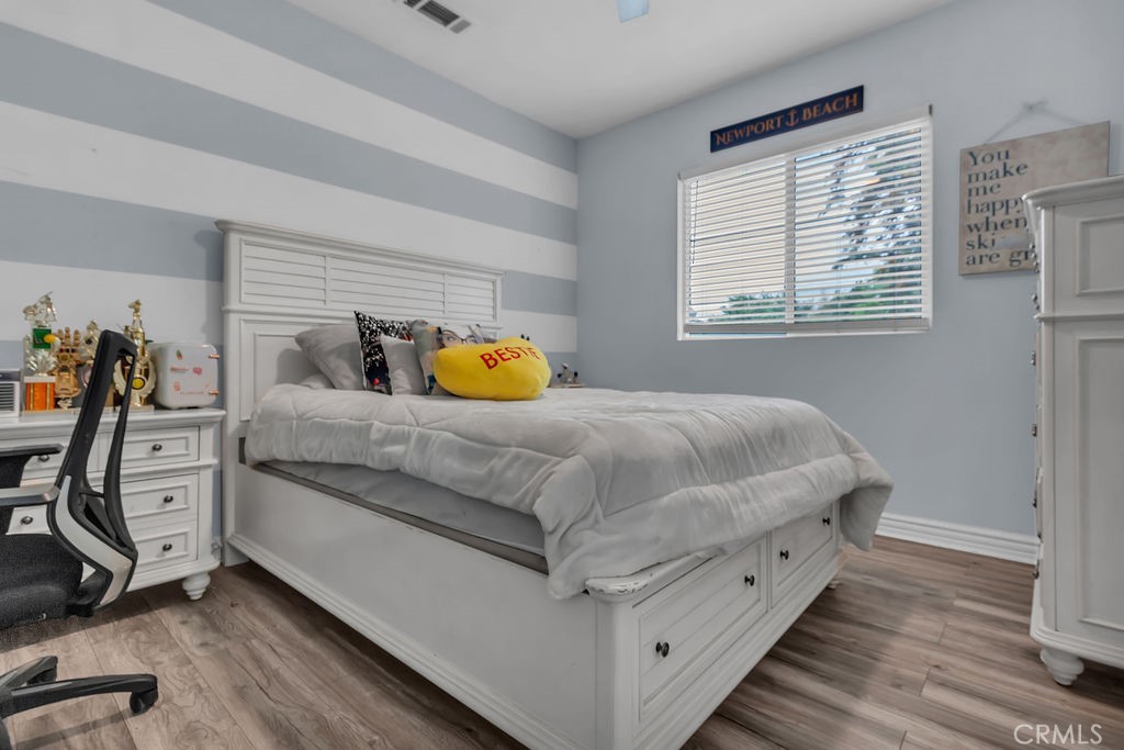 42740 Portraits Lane Temecula, CA 92592 - Photo 46 of 68 a bedroom with a bed and wooden floor