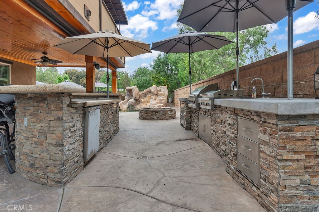 42740 Portraits Lane Temecula, CA 92592 - Photo 58 of 68 a view of a chairs and table under an umbrella in the patio