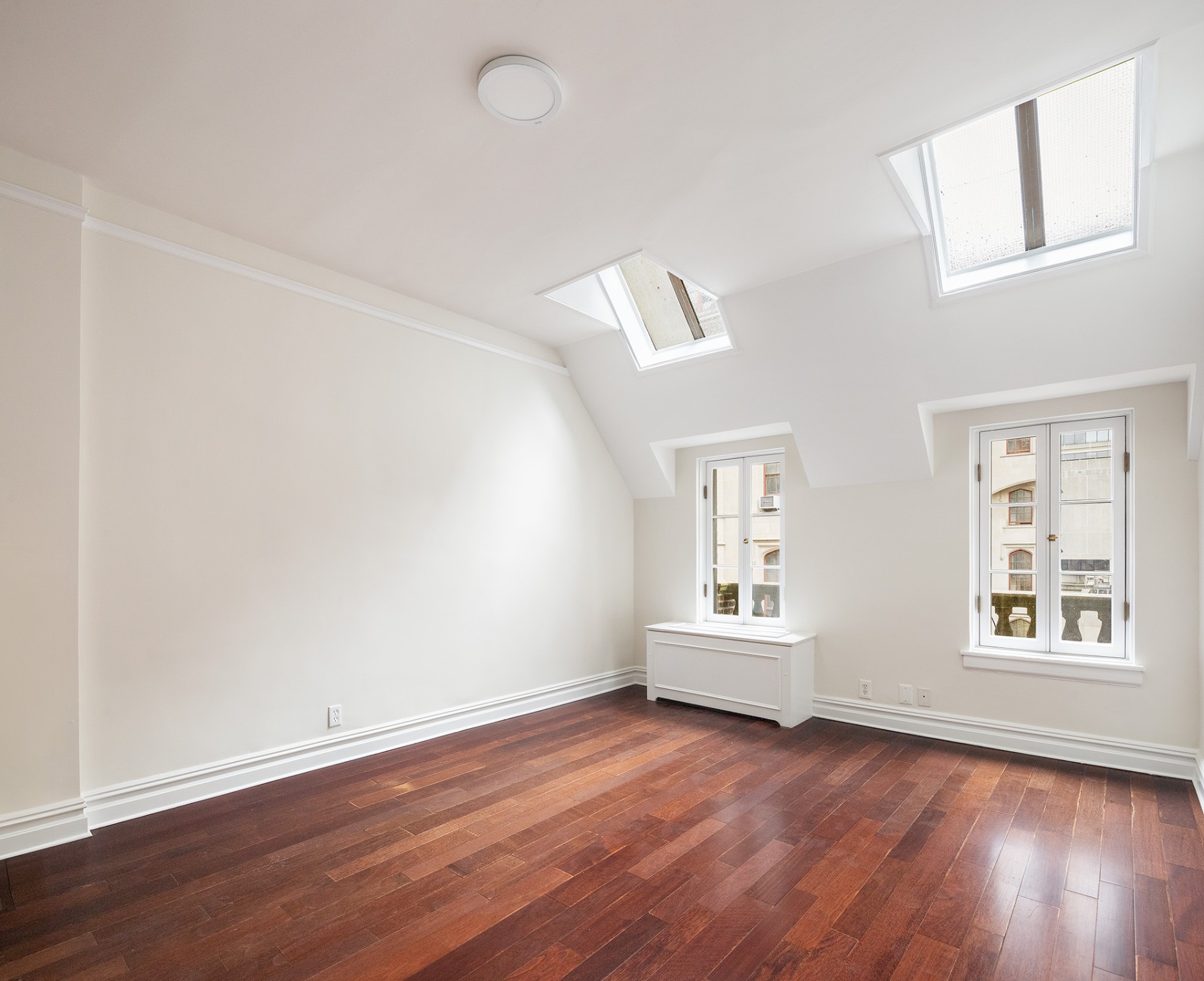 127 East 69th Street, Unit 4 Manhattan, NY 10021 - Photo 9 of 17 an empty room with wooden floor and windows
