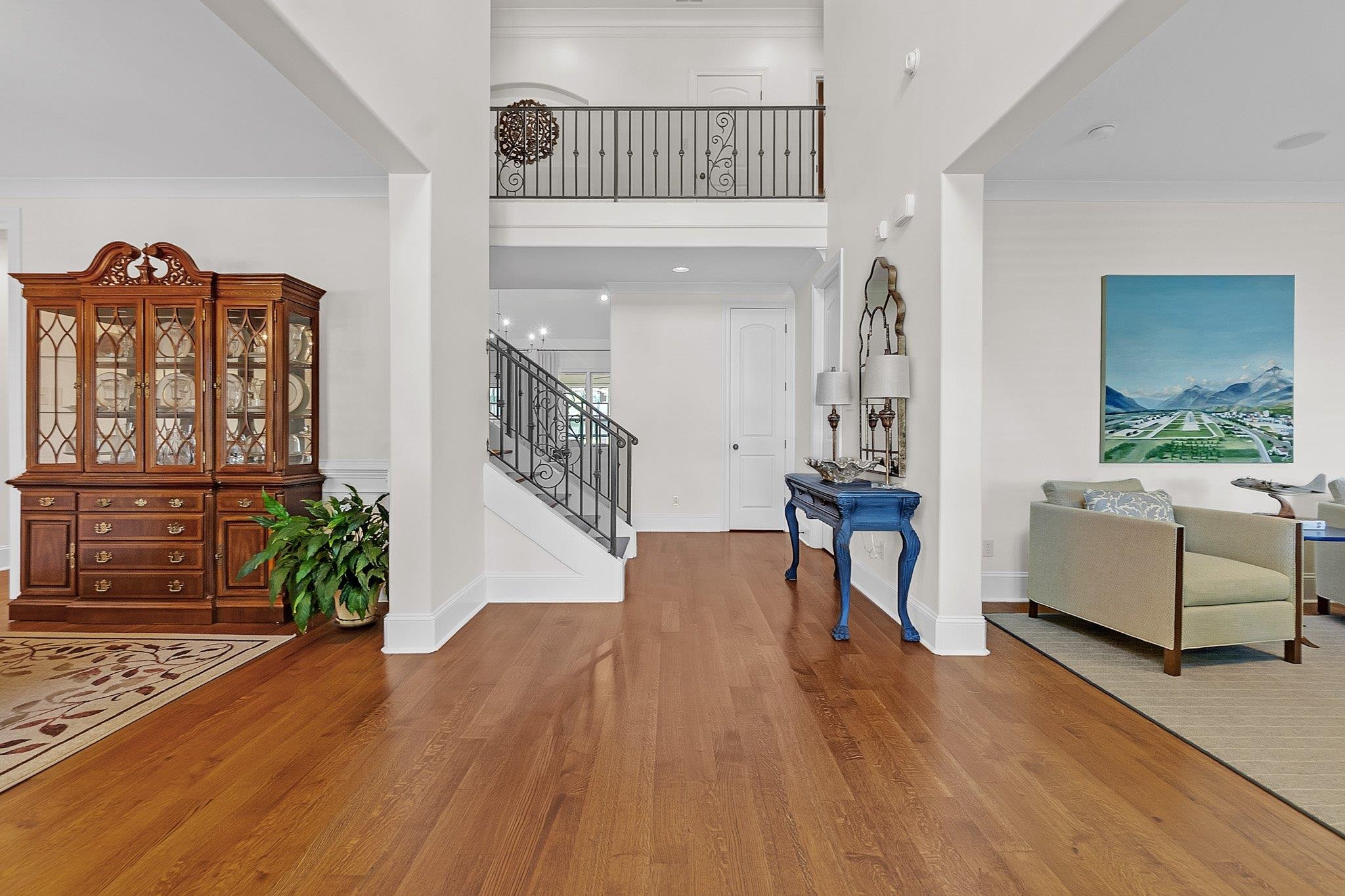 3246 North Hartwell Ridge Drive Collierville, TN 38017 - Photo 5 of 40 Grand foyer featuring rich wood-finish flooring, a prominent staircase with ornate wrought iron railings, an upper-level balcony, high ceilings, and extensive white trimwork