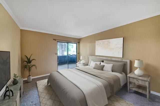 a bedroom with a balcony a bed and a potted plant on the dresser