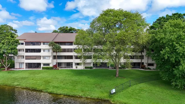 a view of a house with a big yard and large trees