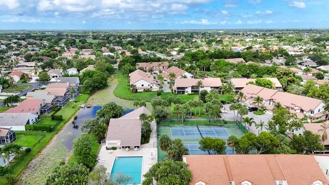 an aerial view of residential houses with outdoor space and trees