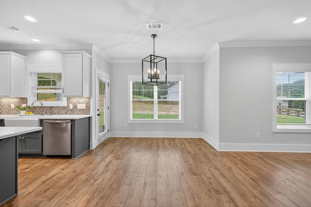 a kitchen with granite countertop a stove a sink wooden floor and a window