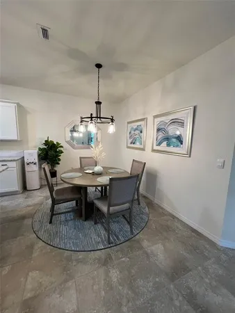 a kitchen with a table chairs microwave and cabinets