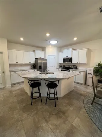a kitchen with kitchen island granite countertop wooden cabinets and center island with chairs