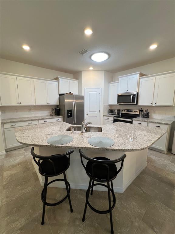 5375 Northwest 48th Lane Ocala, FL 34482 - Photo 28 of 36 a kitchen with kitchen island granite countertop wooden cabinets and center island with chairs