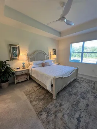 a bed sitting in a spacious bedroom next to a window
