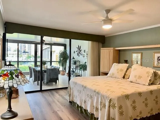 a bedroom with a large bed and a large window with wooden floor