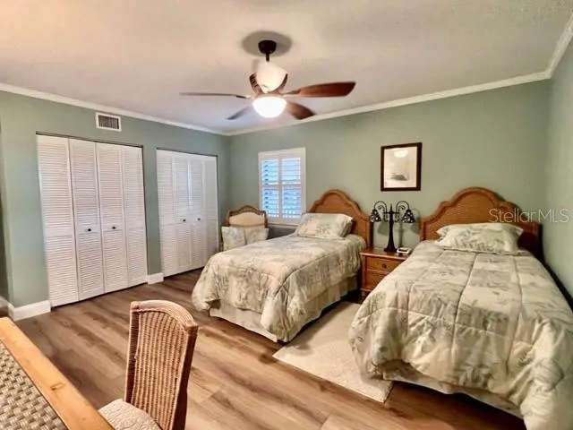 a bedroom with two beds and ceiling fan
