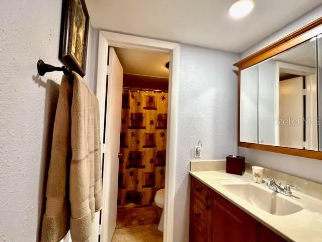 a bathroom with a sink a mirror a vanity and a shower