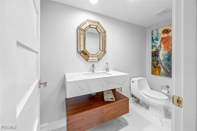 a bathroom with a toilet sink and mirror