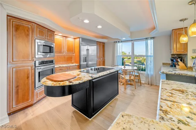 a dining hall with stainless steel appliances granite countertop a sink stove and refrigerator