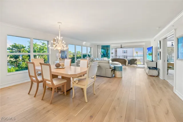 a dining room with furniture a chandelier and wooden floor