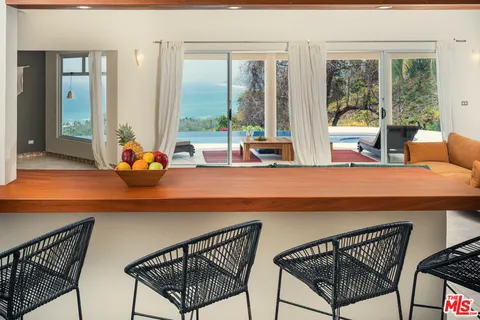 a dining room with furniture and large windows