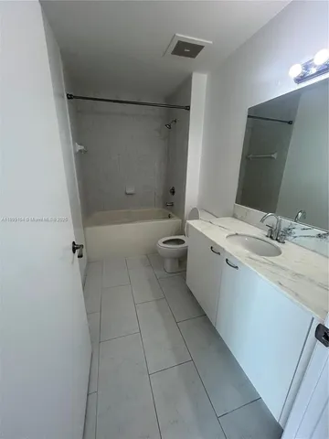 a bathroom with a granite countertop sink a toilet and a mirror