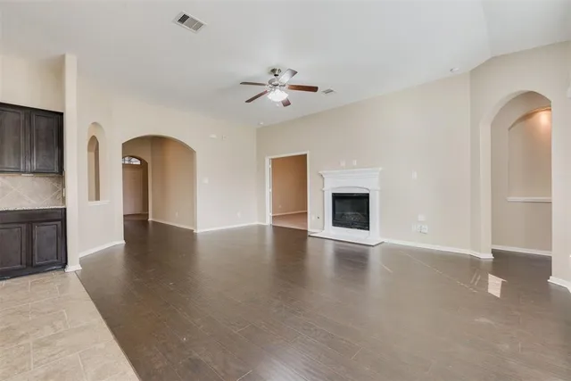 a view of an empty room with window and wooden floor